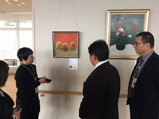 廣州青年美術(shù)家協(xié)會副主席楊健女士，為到場嘉賓、政府官員導(dǎo)賞參展佳作.jpg